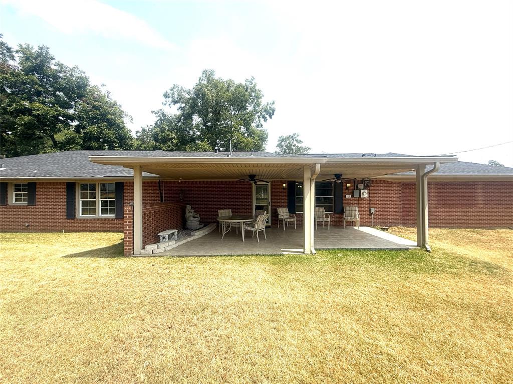304 6th Street Northwest Springhill, LA 71075 - Photo 34 of 38 Brick exterior with covered patio, concrete slab, and ceiling fans