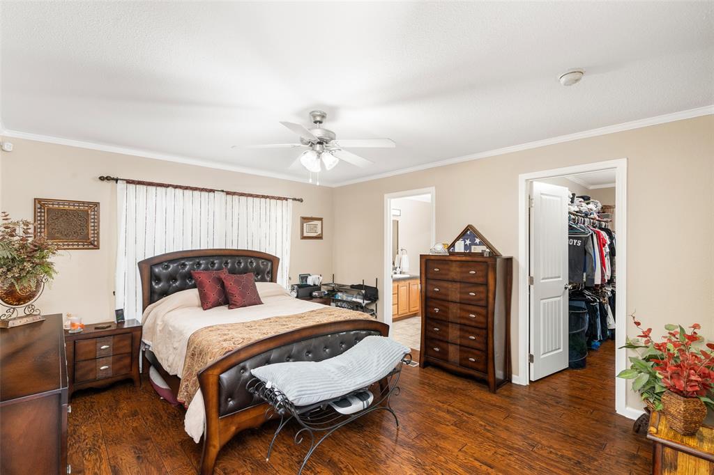 360 Rockcrest Road McKinney, TX 75071 - Photo 19 of 20 Bedroom with ornamental molding, dark wood finished floors, a walk in closet, a ceiling fan, and ensuite bath