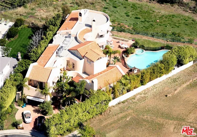 an aerial view of a house with a yard and lake view