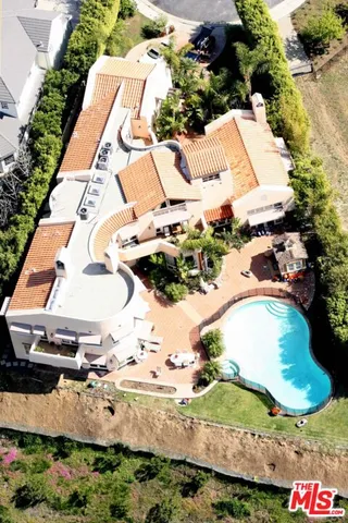 an aerial view of a house with a yard and pool
