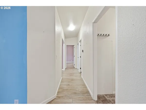 a view of a hallway with wooden floor