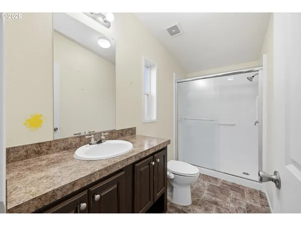 a bathroom with a granite countertop sink toilet a mirror and shower