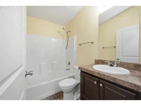 a bathroom with a granite countertop sink toilet a mirror and shower