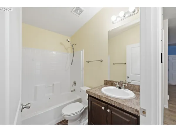 a bathroom with a granite countertop sink toilet mirror and bathtub