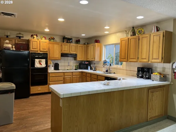 a kitchen with stainless steel appliances granite countertop a sink refrigerator and cabinets