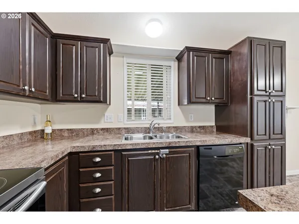 a kitchen with granite countertop stainless steel appliances a sink stove and cabinets