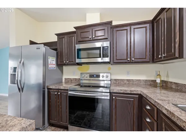 a kitchen with stainless steel appliances granite countertop a stove microwave and refrigerator