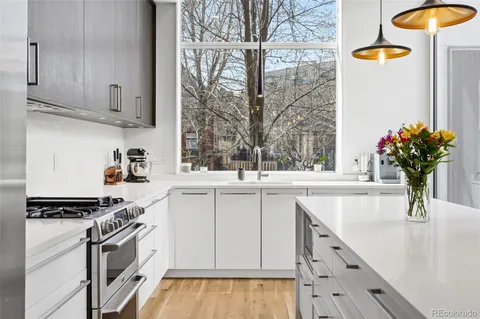 a kitchen with stainless steel appliances kitchen island granite countertop a stove a sink and a refrigerator