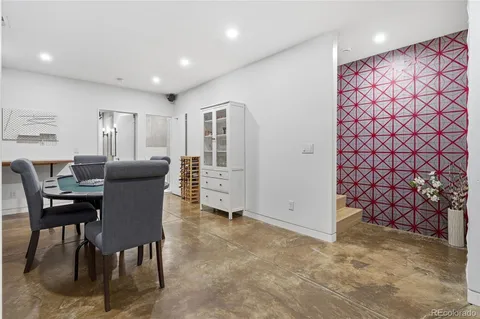 a kitchen with stainless steel appliances granite countertop a table chairs sink and cabinets