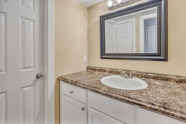 a bathroom with a granite countertop sink and a mirror