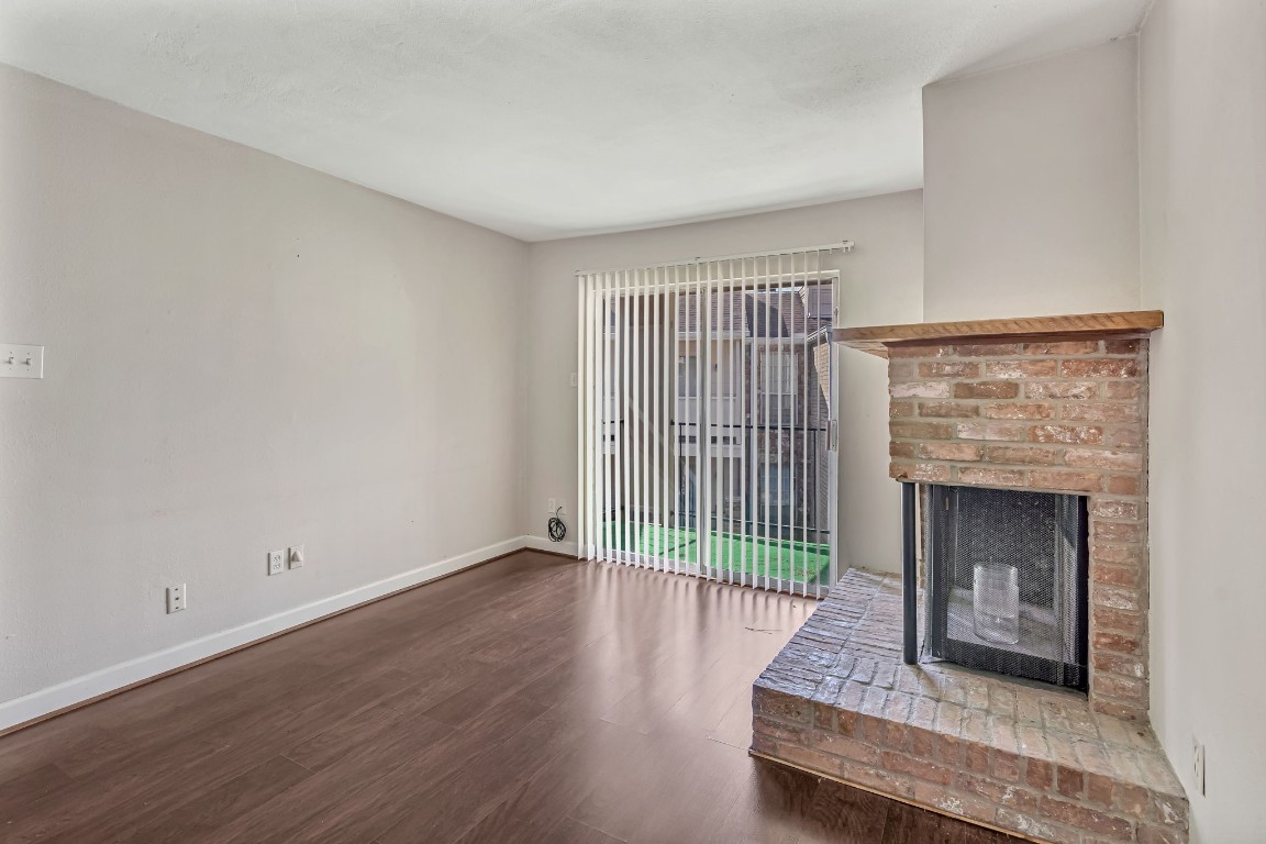 2800 Jeanetta Street, Unit 602 Houston, TX 77063 - Photo 8 of 29 a living room with a fireplace and wooden floor