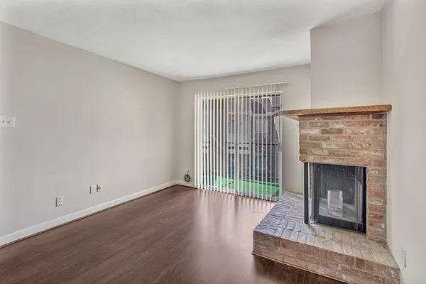 a living room with a fireplace and wooden floor