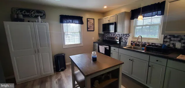 a kitchen with stainless steel appliances a sink stove and refrigerator