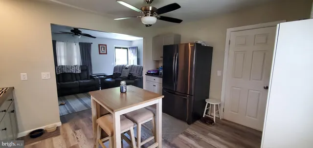 a kitchen with stainless steel appliances granite countertop a refrigerator a sink a stove and a refrigerator with wooden floor