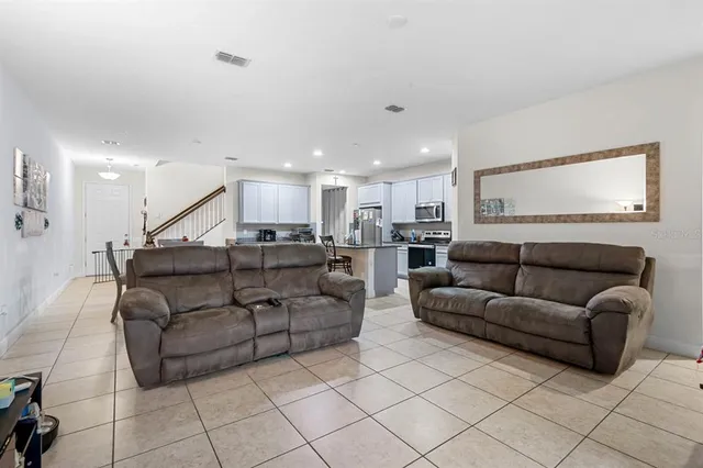 a living room with furniture and kitchen view