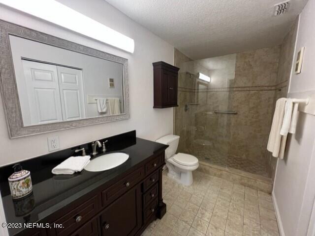 400 Sandiron Circle, Unit 418 Ponte Vedra Beach, FL 32082 - Photo 15 of 25 a bathroom with a sink a toilet a mirror and shower