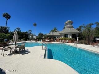 400 Sandiron Circle, Unit 418 Ponte Vedra Beach, FL 32082 - Photo 23 of 25 a view of a swimming pool with a table and chairs