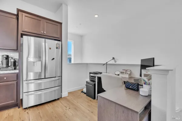 a kitchen with stainless steel appliances a refrigerator and wooden floor