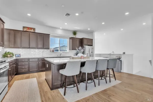 a kitchen with a dining table chairs and wooden floor