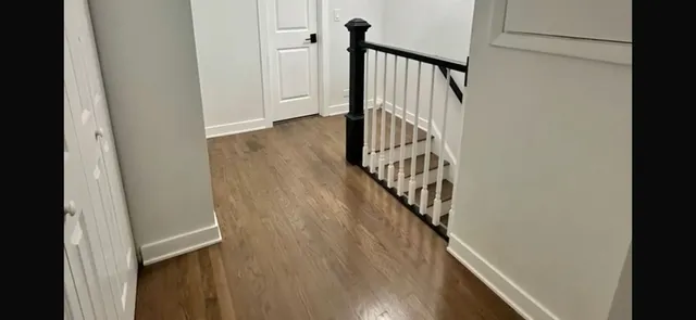 a view of staircase with wooden floor and white walls