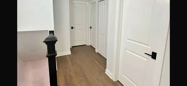 a view of a hallway with wooden floor