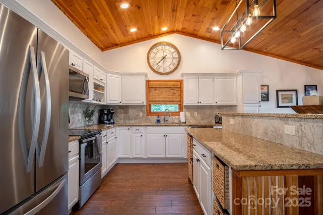 a kitchen with stainless steel appliances granite countertop a stove a sink and a refrigerator