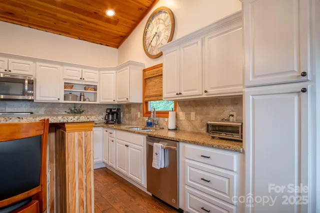 a kitchen with stainless steel appliances granite countertop a sink a stove and cabinets