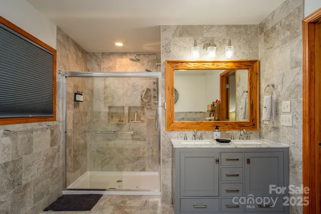 a bathroom with a granite countertop sink mirror and shower