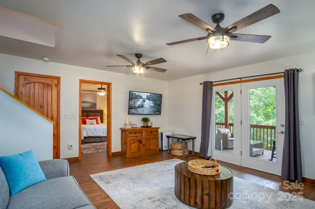 a living room with furniture a large window and a chandelier