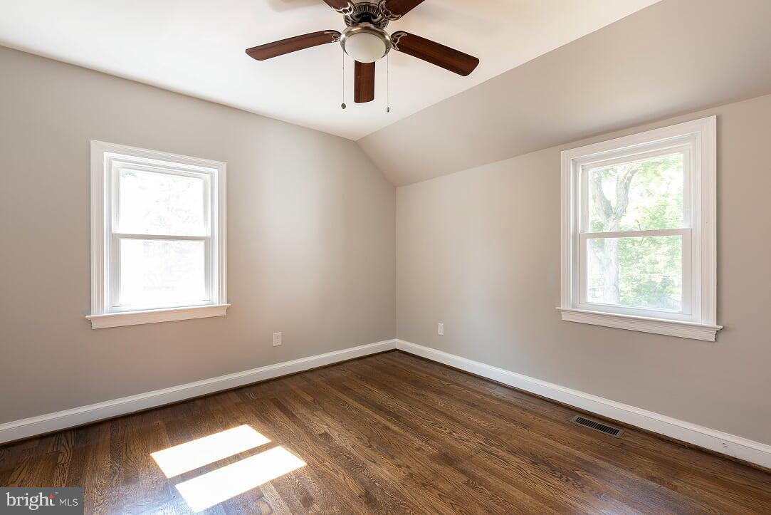 2208 Shepherd Street Northeast Washington, DC 20018 - Photo 16 of 19 an empty room with wooden floor chandelier fan and windows
