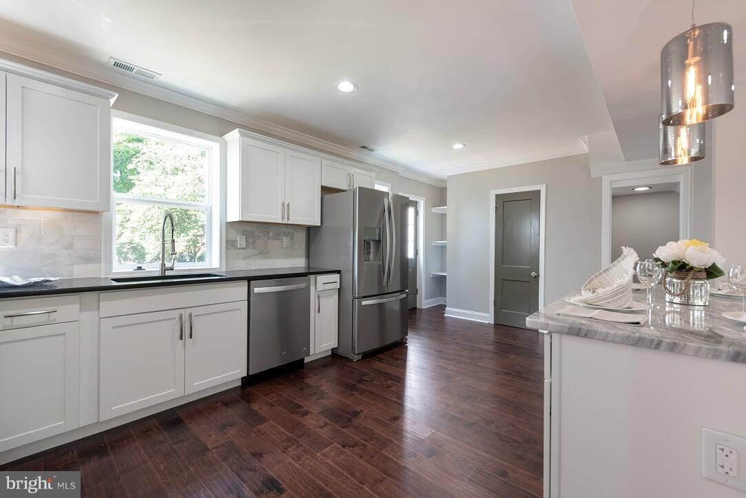 2208 Shepherd Street Northeast Washington, DC 20018 - Photo 10 of 19 a kitchen with granite countertop stainless steel appliances a refrigerator sink and wooden floor