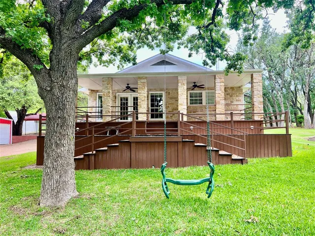 a backyard of a house with a garden and outdoor seating