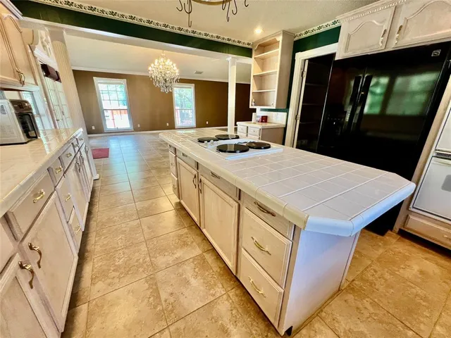 a kitchen with stainless steel appliances kitchen island granite countertop a refrigerator a sink and dishwasher with wooden floor