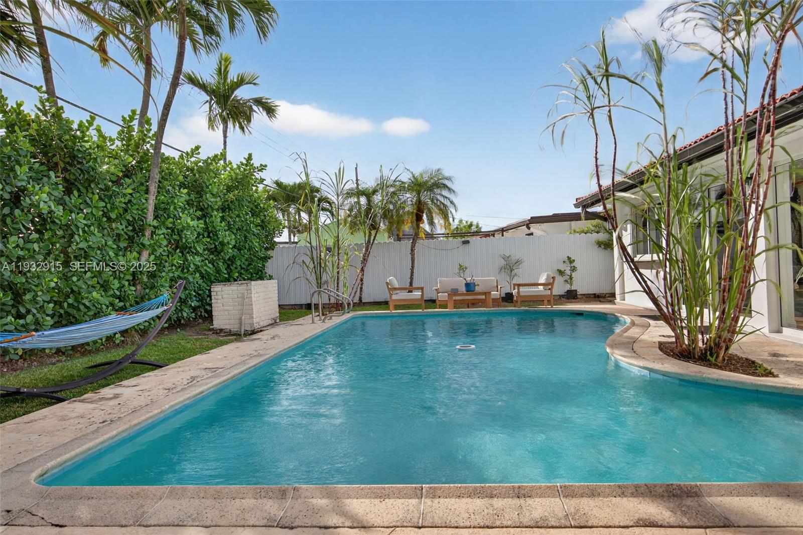 11260 Southwest 48th Street Miami, FL 33165 - Photo 44 of 48 a view of a swimming pool with an outdoor space and seating area