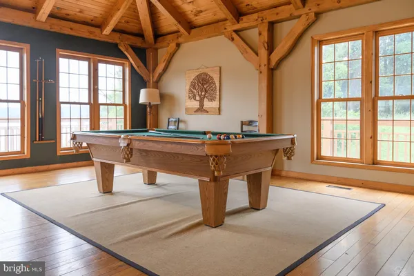 a room with wooden floor table and chairs