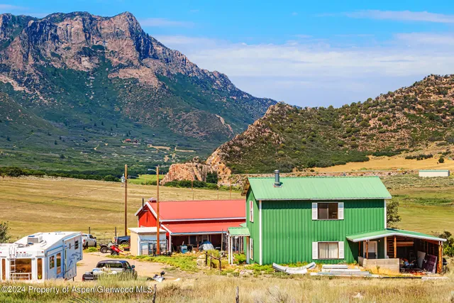 a view of a dry yard with mountains in the background