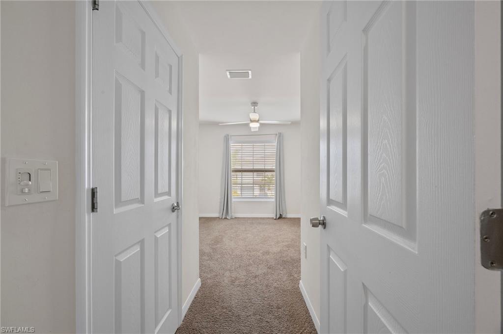15071 Wildflower Circle Naples, FL 34119 - Photo 15 of 34 a view of a hallway with windows