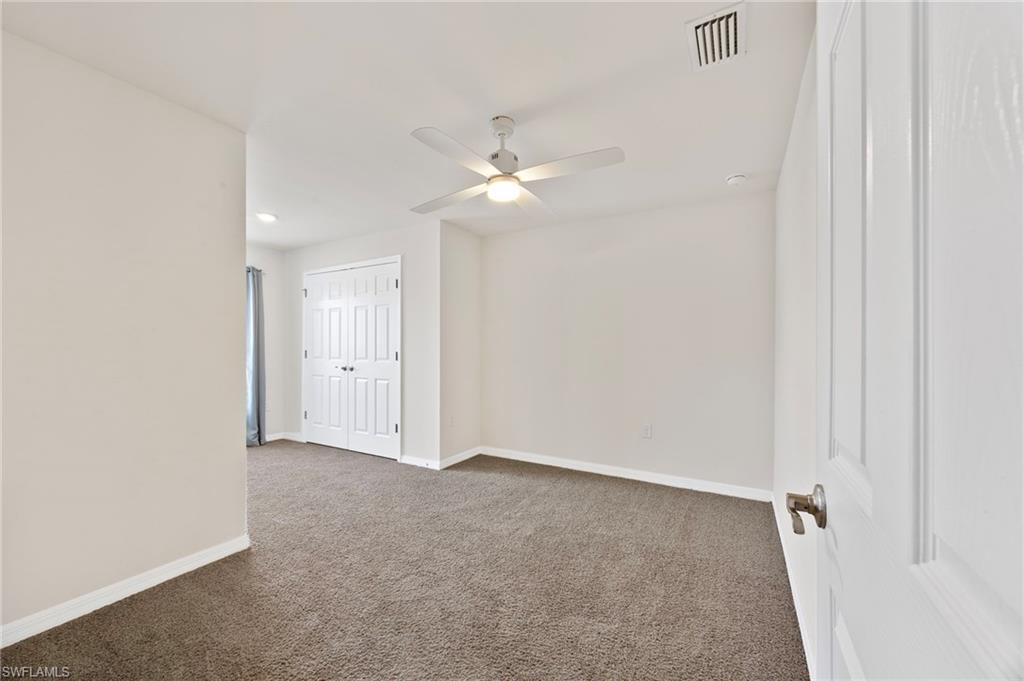 15071 Wildflower Circle Naples, FL 34119 - Photo 4 of 34 an empty room with a ceiling fan and a window