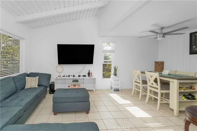 a living room with furniture a flat screen tv and a window