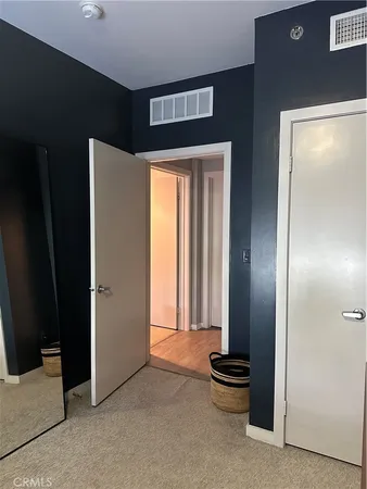 an empty room with a mirror and front door