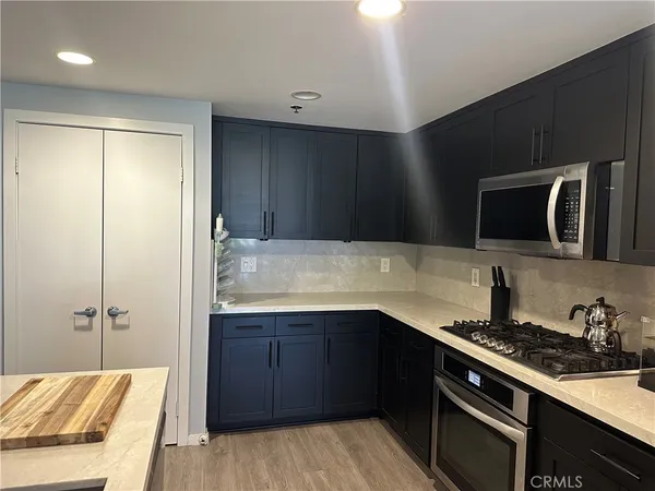 a kitchen with a sink and a stove top oven with wooden floor