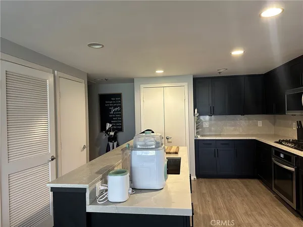 a kitchen with stainless steel appliances granite countertop a sink and a refrigerator
