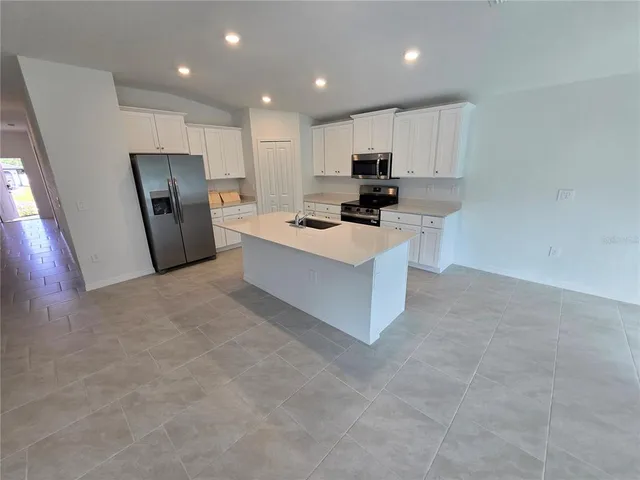 a kitchen with stainless steel appliances a refrigerator sink microwave and cabinets