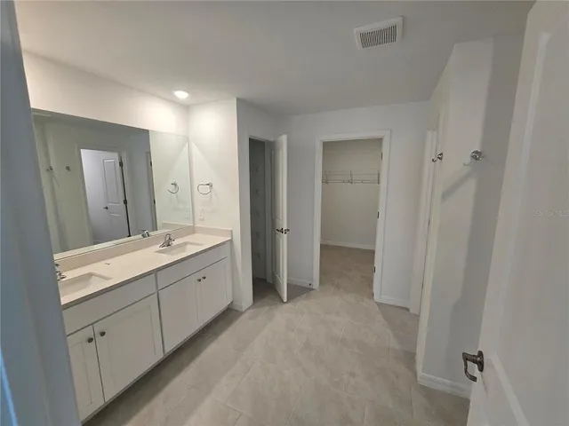 a large bathroom with a double vanity sink and mirror