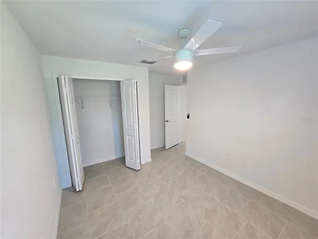 an empty room with a ceiling fan and bathroom