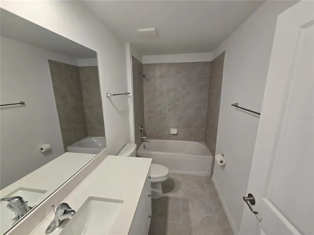 a bathroom with a sink a toilet a tub and shower
