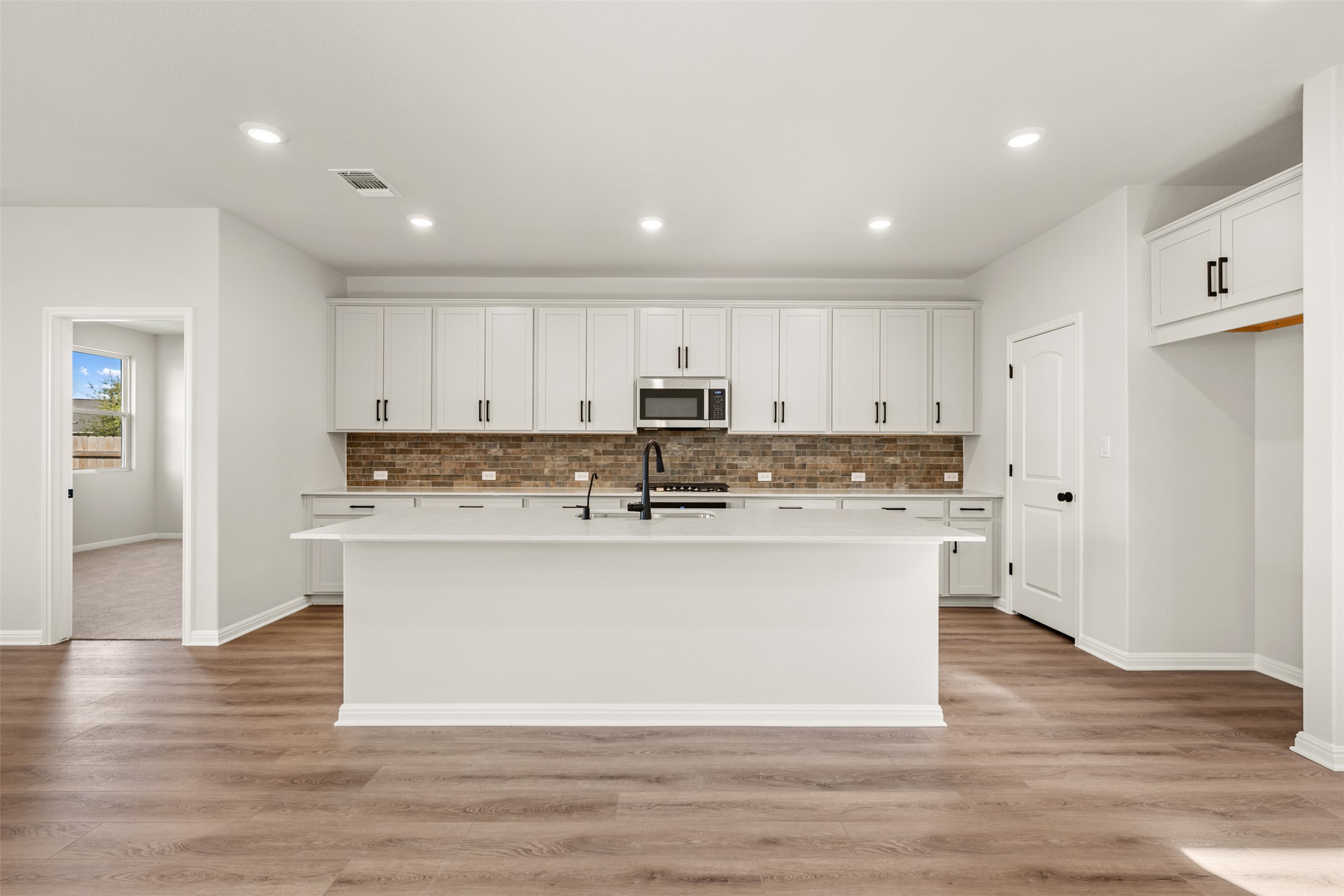 1036 Sienna Bear Road Georgetown, TX 78633 - Photo 30 of 33 a large kitchen with stainless steel appliances granite countertop a stove a sink and a refrigerator