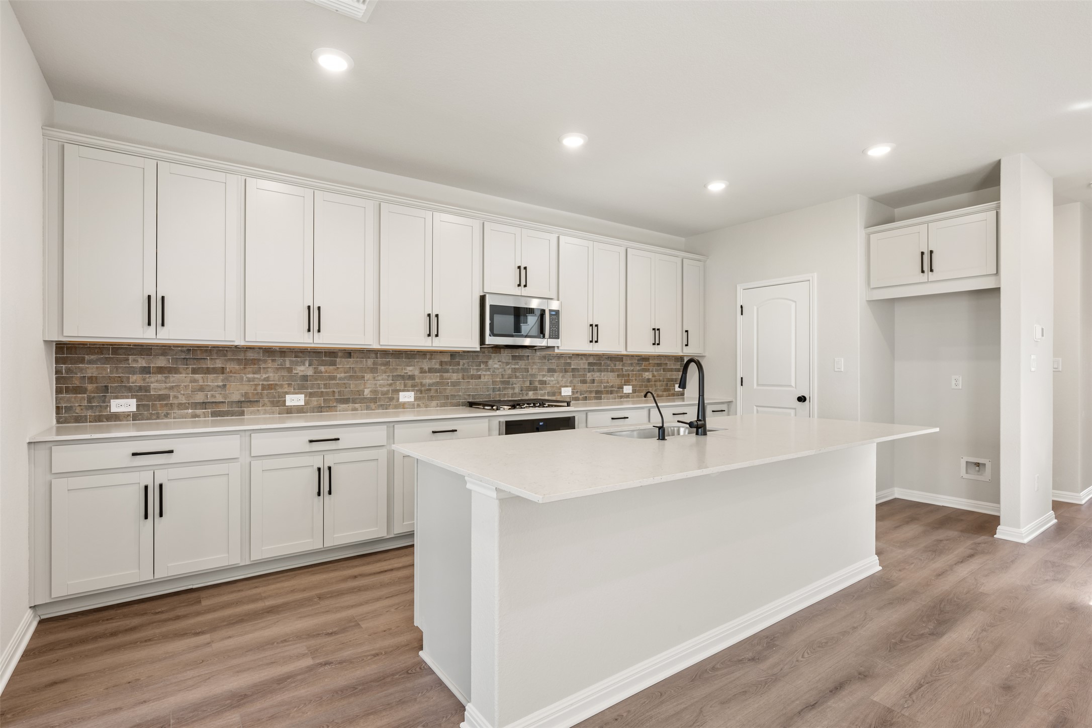 1036 Sienna Bear Road Georgetown, TX 78633 - Photo 7 of 33 a kitchen with white cabinets appliances and a sink