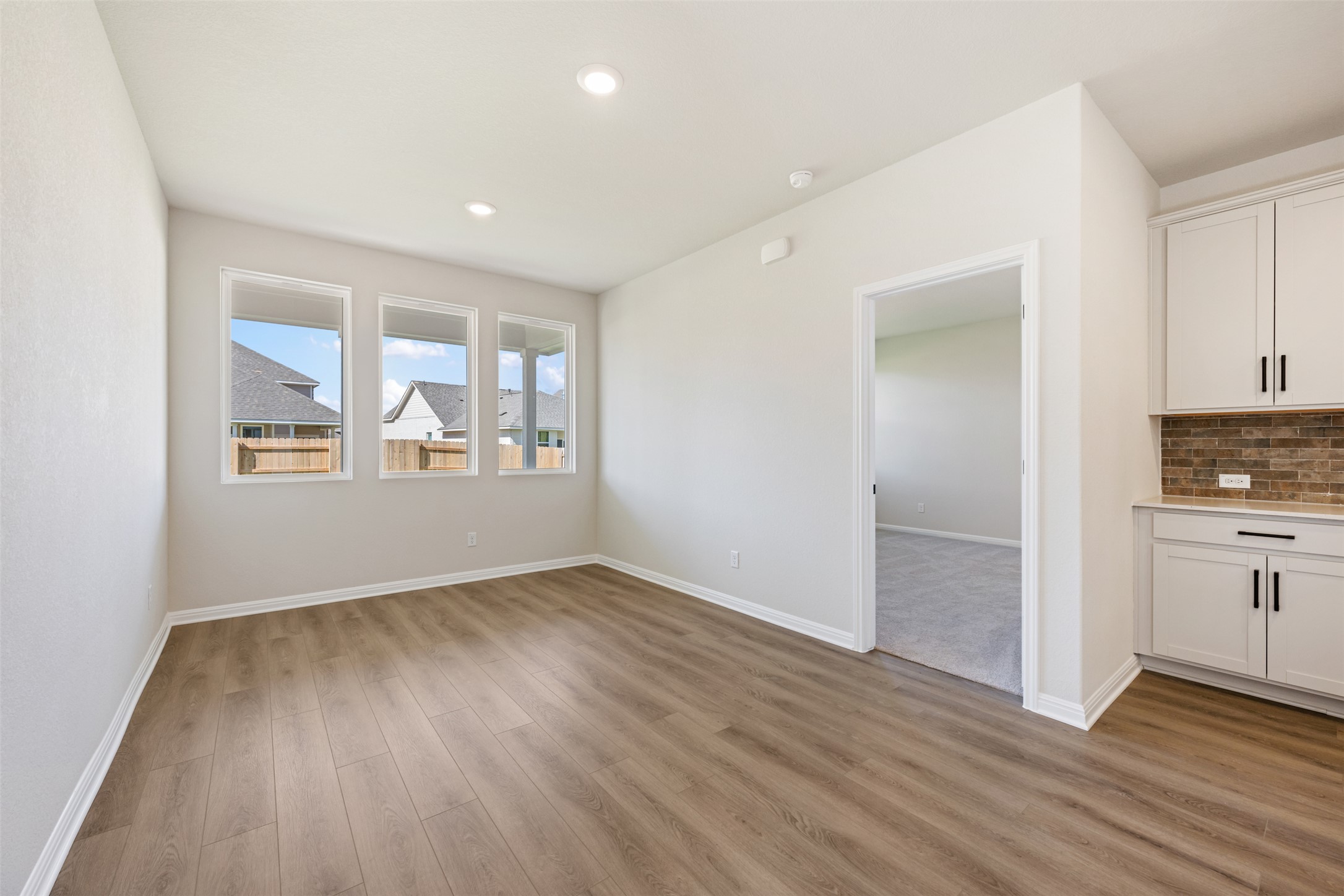 1036 Sienna Bear Road Georgetown, TX 78633 - Photo 8 of 33 a view of an empty room with a window and wooden floor
