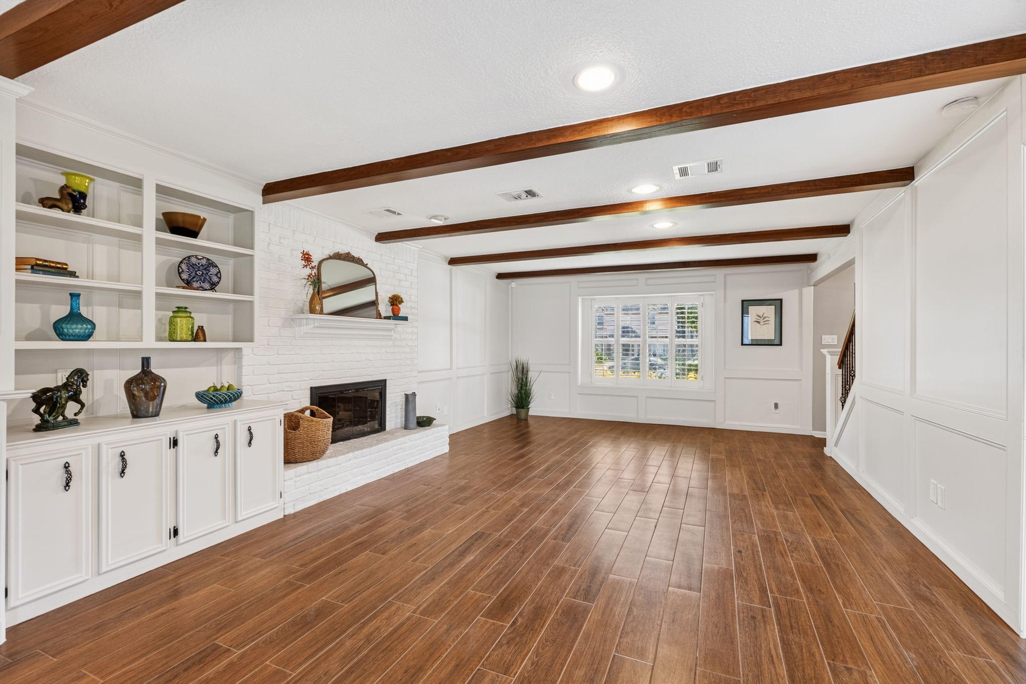 3414 Flaming Candle Drive Spring, TX 77388 - Photo 8 of 50 FAMILY ROOM - The wood-look tile flooring coordinates with the wood beams in the ceiling to give this room a very polished and updated look. The block paneling has been painted, as well as the built-in shelves & cabinetry.